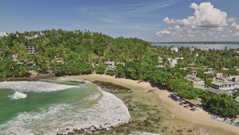 mirissa sri lanka aerial v18 cinematic drone flyover bay capturing beautiful golden sandy beach, hillside beachfront resort hotels and blue ocean views - shot with mavic 3 cine - april 2023