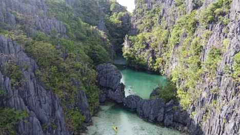 Gente-En-Kayak-De-Mar-Explorando-Una-Pequeña-Laguna-Tropical-En-El-Nido-En-Un-Tour-De-Isla-En-Isla