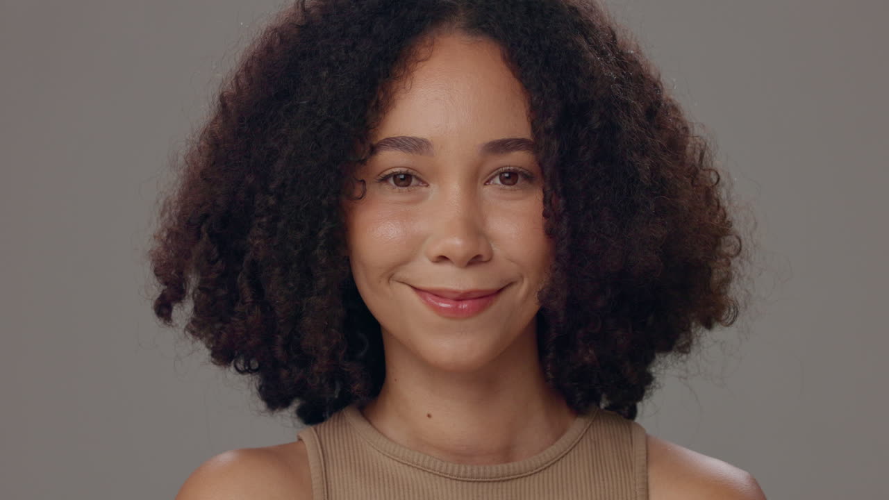 retrato de una mujer sonriente con el cabello rizado