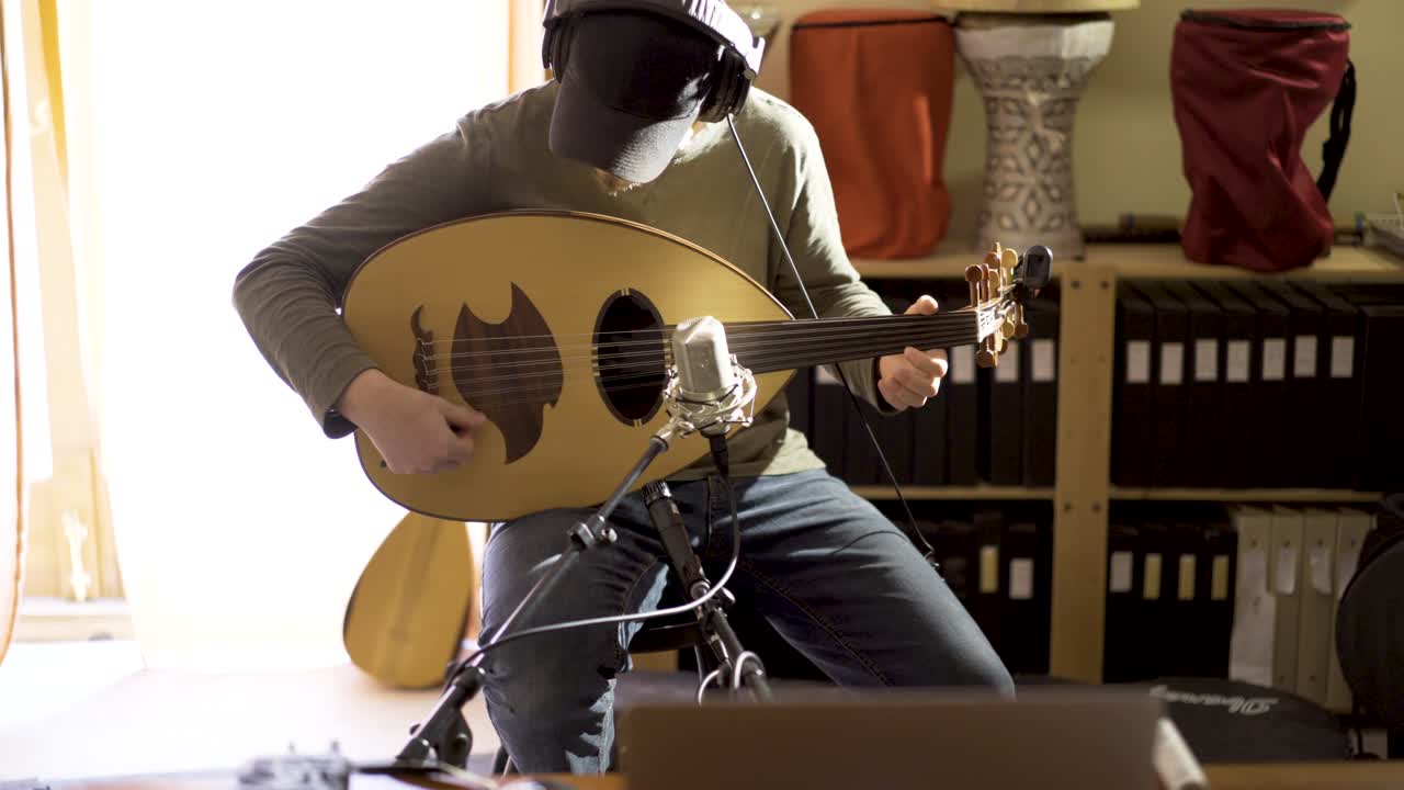 Musician playing an oud in a studio