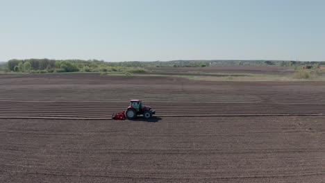 a tractor with blades cuts holes to prepare the field before planting. agricultural machinery.