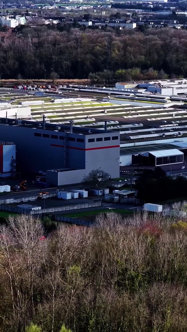Vertikalt luftfoto med sideudsigt af stor lastbilproduktionsfabrik med industrikonpleks, fabriksbygninger, samleanlæg og bilproduktionssted i Frankrig.