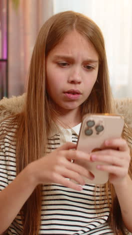 Child girl kid sad after losing mobile game on smartphone reading bad result of online school test