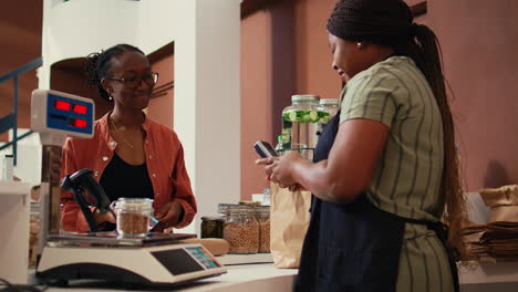 woman using card payment at pos to buy fresh produce