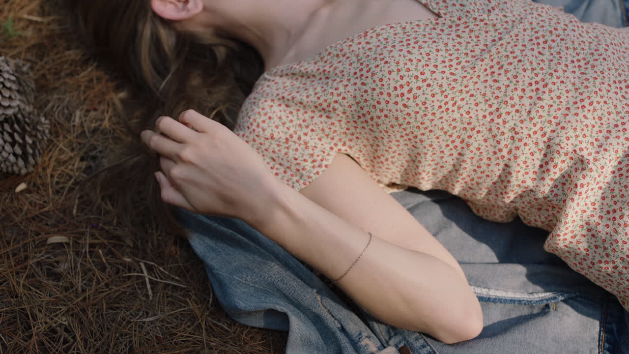 ragazza della natura che gioca con i capelli sdraiata a terra nella foresta sognando ad occhi aperti rilassandosi nel bosco