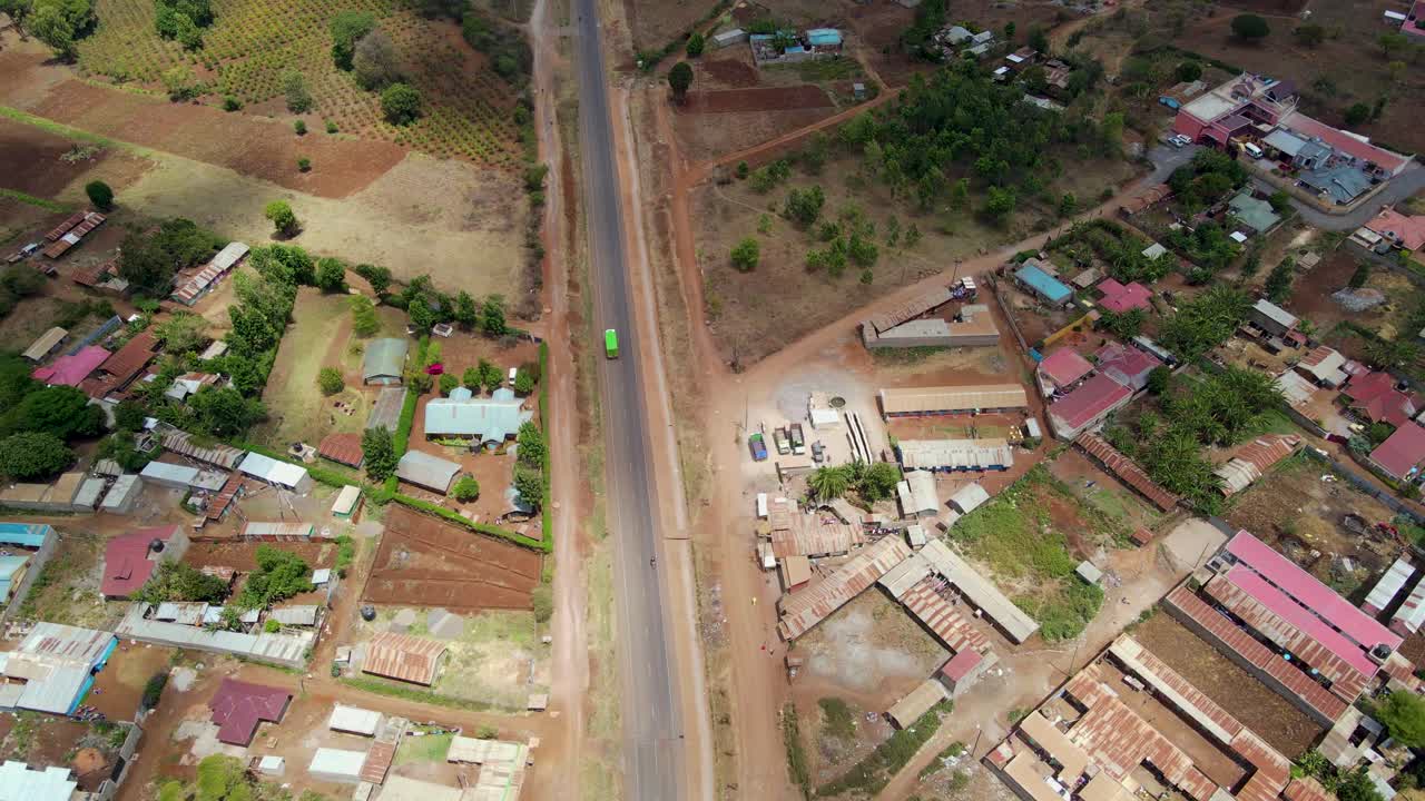 Vista aerea di una città e campi illuminati dal sole, ora d'oro nell'Africa rurale - ripresa in tracking con drone