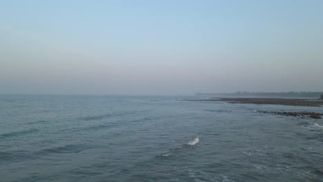 small waves rooling at a rocky beach during twilight at saint martin island in bangladesh