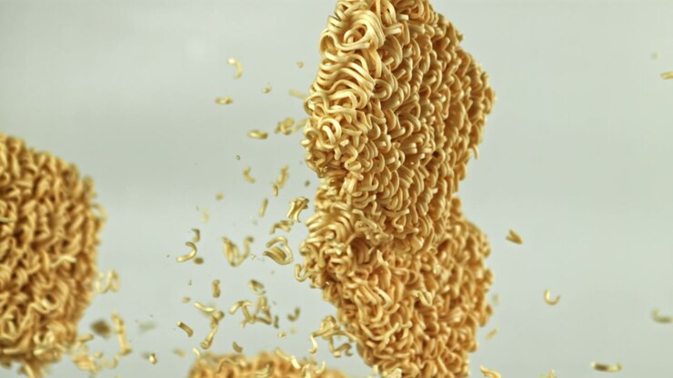 Noodles istantanei secchi che galleggiano e si rompono al rallentatore