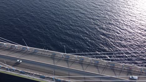 aerial view of cars passing over a suspended bridge at sunset, antirion bridge, corinthian straight, greece.