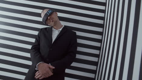 man in a suit with blindfold against striped background