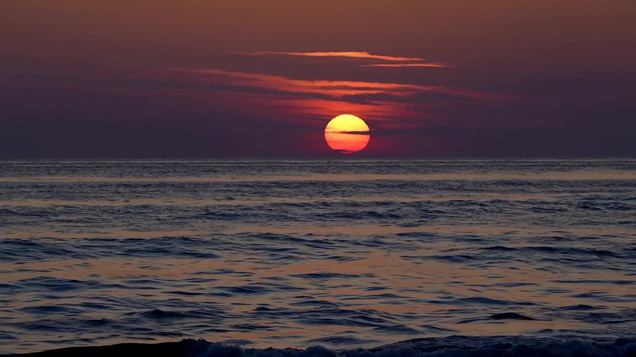 海の地平線にかかる黄金色の夕焼け