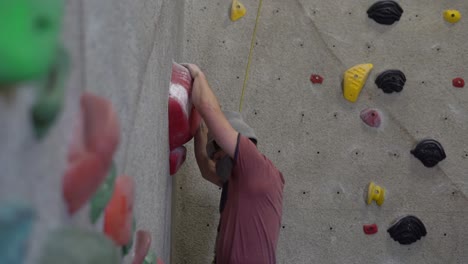 rock climber climbing an indoor rock wall using athletic chalk for grip-4