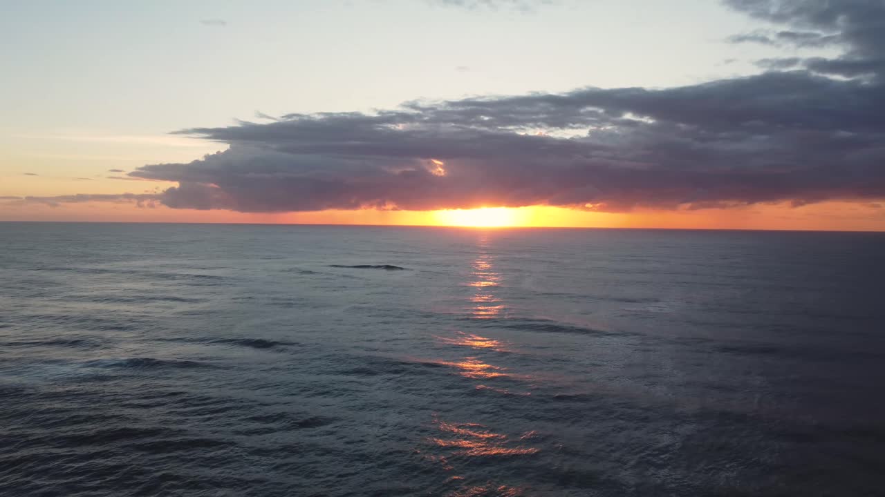 Drone rise shot with orange sunrise and clouds with surfer in ocean at Blue Bay Beach The Entrance Central Coast NSW Australia 3840x2160 4K