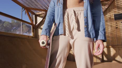 video of midsection of caucasian female skateboarder training in skate park