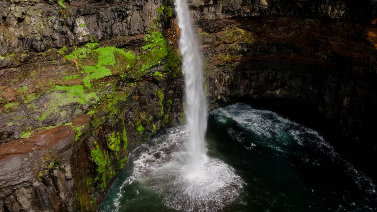 una cascada se sumerge en un cañón de musgo, evocando serenidad y poder natural