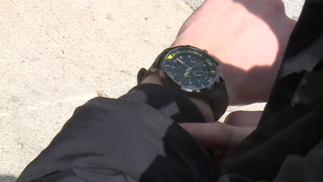 hombre comprobando la hora en el reloj de pulsera