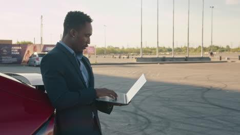 businessman working on a laptop in a parking lot