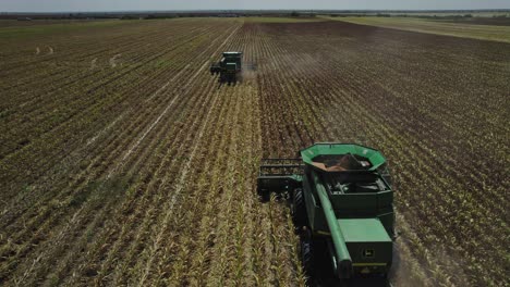 AERIAL---Combine-harvester-cultivating-land,-agriculture-field,-Mexico,-wide-forward-shot