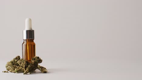 Video-of-marijuana-buds-and-bottle-of-cbd-extract-on-white-background