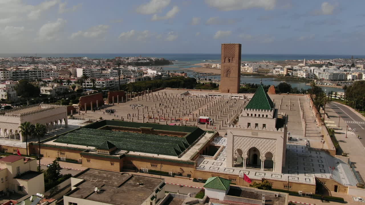 Fantastisk HD-luftpanorama af det ikoniske Hassan-tårn og Mausoleet for Mohammed den Femte i Rabat, Marokko. Dette vidvinkelbillede fanger den historiske arkitektur og marmorsøjlerne mod baggrunden.