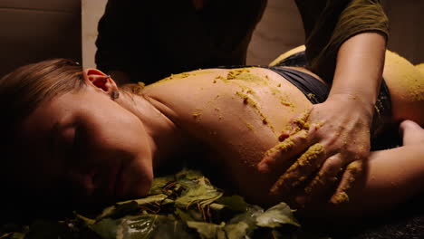 mujer recibiendo un masaje de espalda con exfoliante corporal