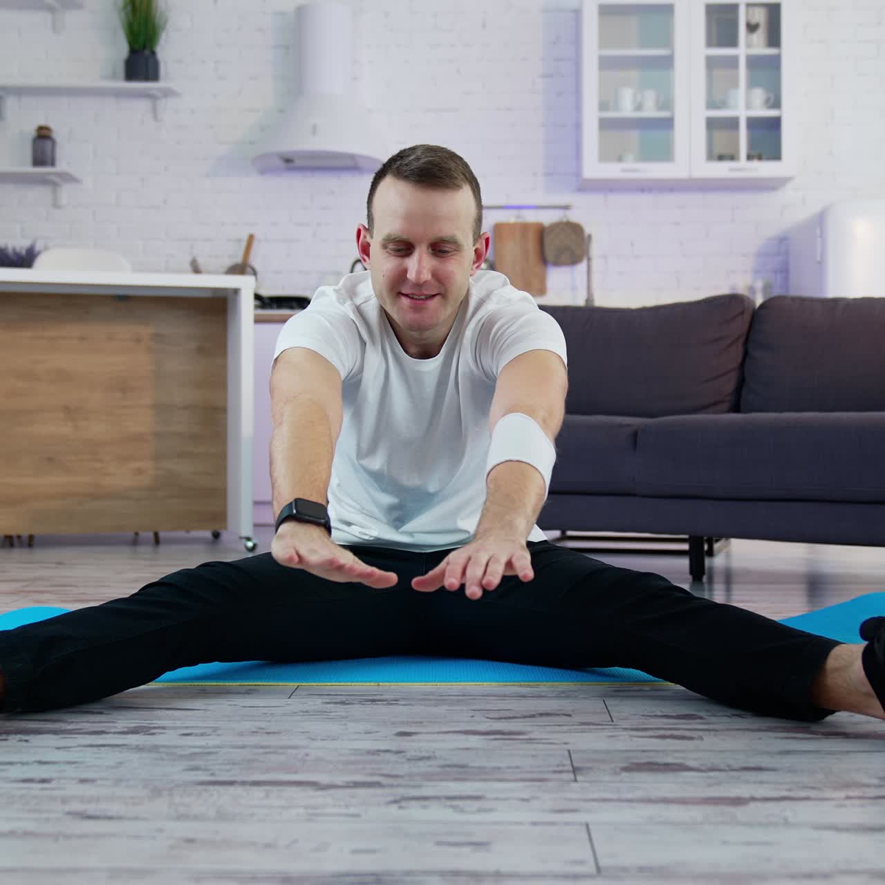 Sport exercises at home. A man does a warm-up before starting to exercise