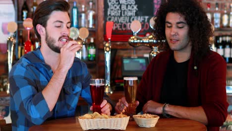 friends interacting while having beer and snacks