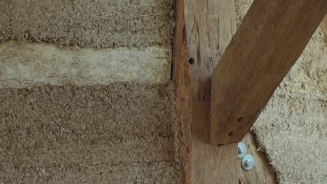 close-up vertical panning down over hempcrete wall with timber frame during construction