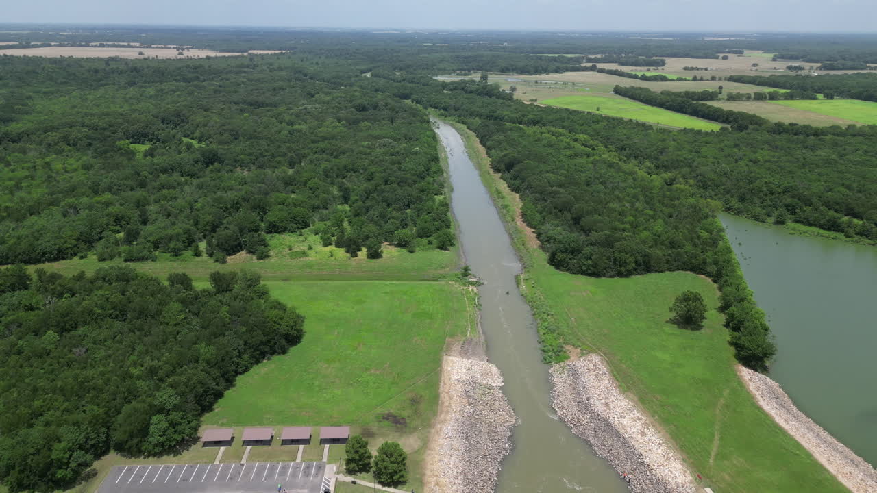 Drone high angle flying back slowing revealing a lakes spillway. Shot in 4k 60fps and in 10 bit 422.