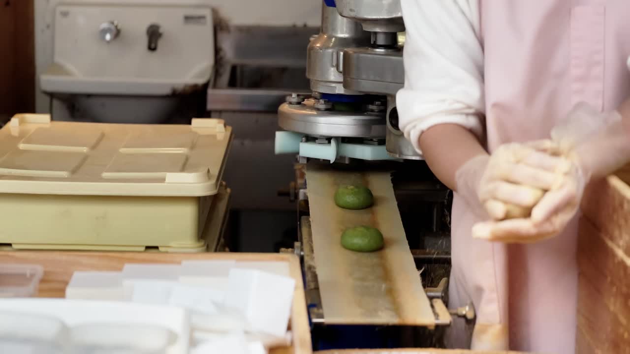 manos para hacer mochi verde pegajoso glutinoso en una fábrica