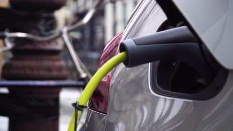 coche eléctrico cargando en el fondo una bicicleta en ámsterdam