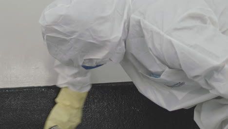 close up shot of a soldier in protective gear sanitizing walls of a hospital after covid-19 contamination