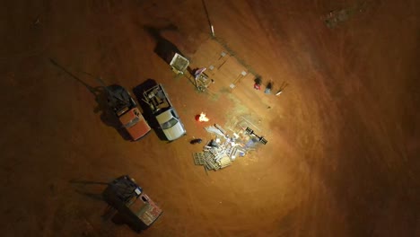 descending shot of bonfire crew on the infield of oval dirt race track during a race