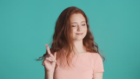 Redheaded-girl-looking-at-camera-on-turquoise-background.