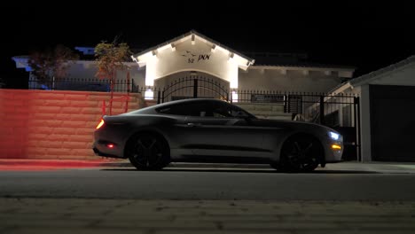 luxury sports car parks on street in front of house at night