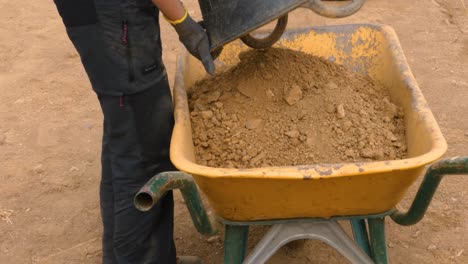 transporting dirt and sand into an old wheelbarrow