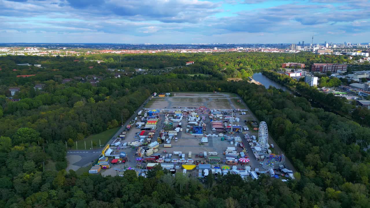 Berlin funfair showing a Ferris wheel, amusement rides, and various stalls from an aerial perspective. Lovely aerial view flight panorama overview drone