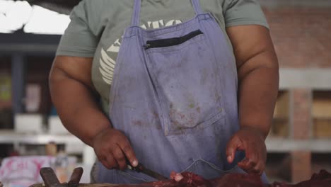 african woman cutting the meat