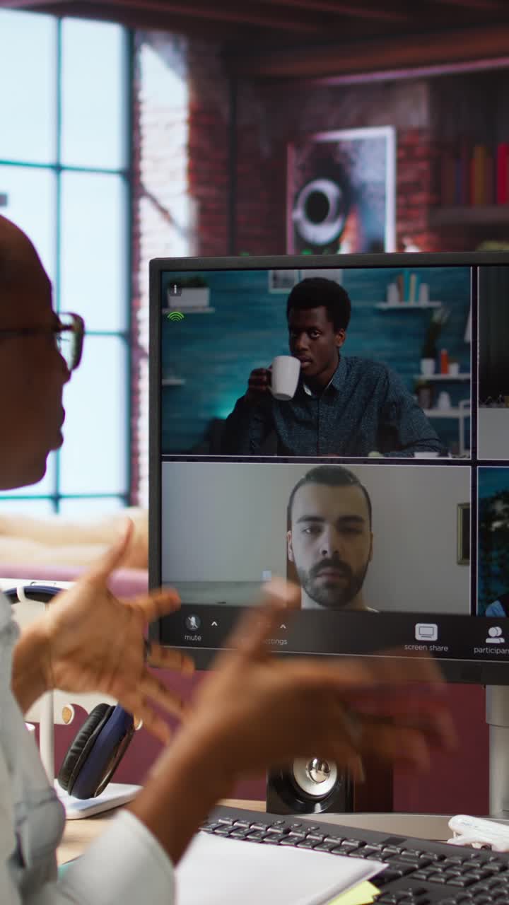 Vertical video Manager greeting employees during videocall from home, looking over paperwork