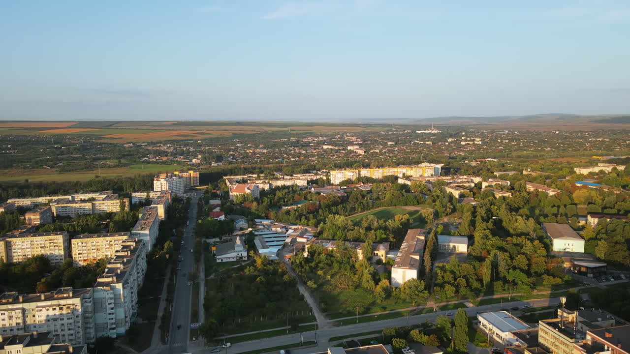 Aerial drone view of Balti, Moldova at sunset. Road with cars, residential buildings, greenery