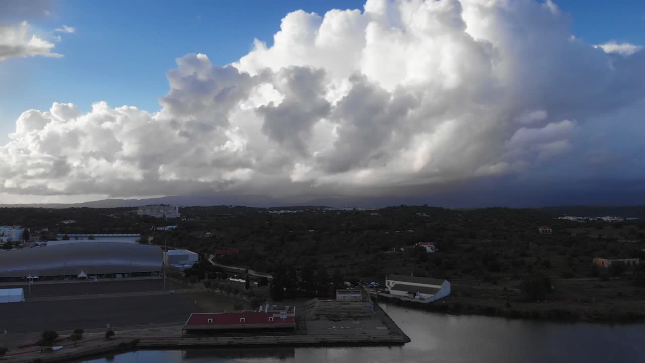 Ascending aerial panorama over Portimao town and Arade river during clouds and sun,Portugal