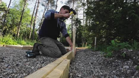 portrait of a carpenter working on form outdoors. hitting wooden stake with a sledge hammer.