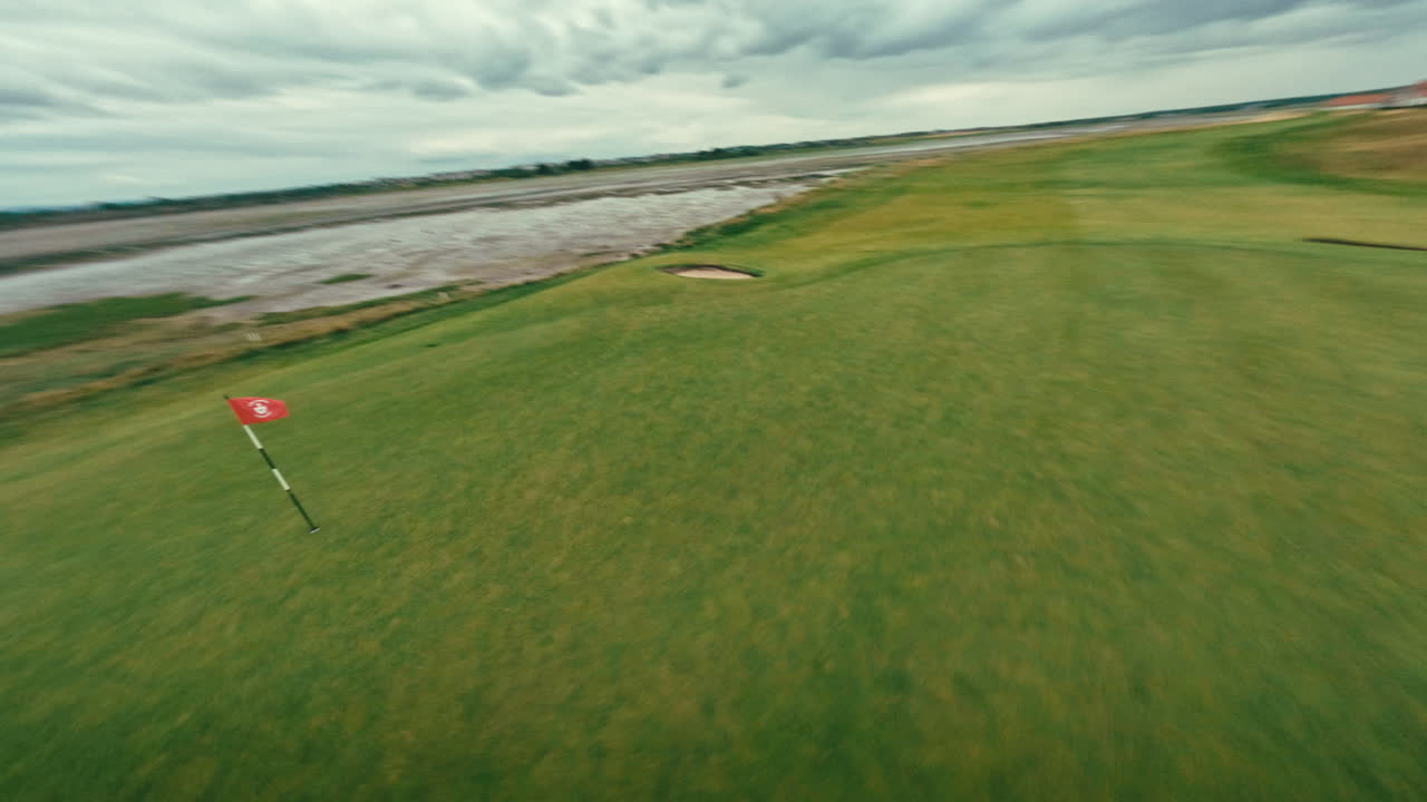 fpv 드론은 해안 아일랜드 링크 골프 코스의 롤링 그린 (rolling green) 에 녹색을 넣고 날아다닙니다.