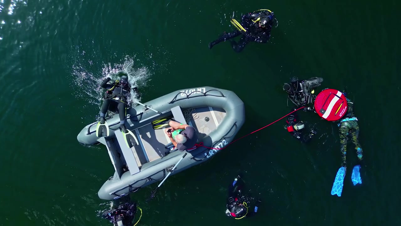 Toma cinematográfica aérea a cámara lenta de buzos en un lago, Drone.