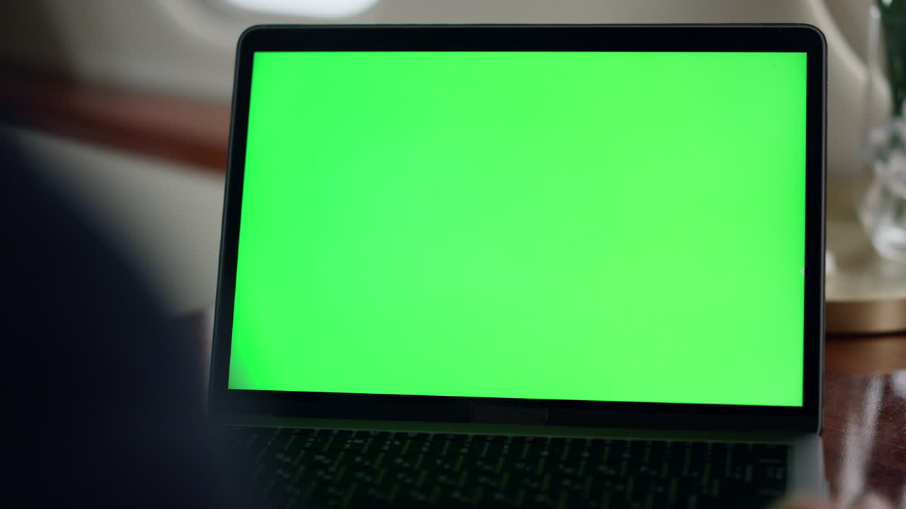 Closeup mockup laptop screen in airplane. Businessman watch chroma key computer