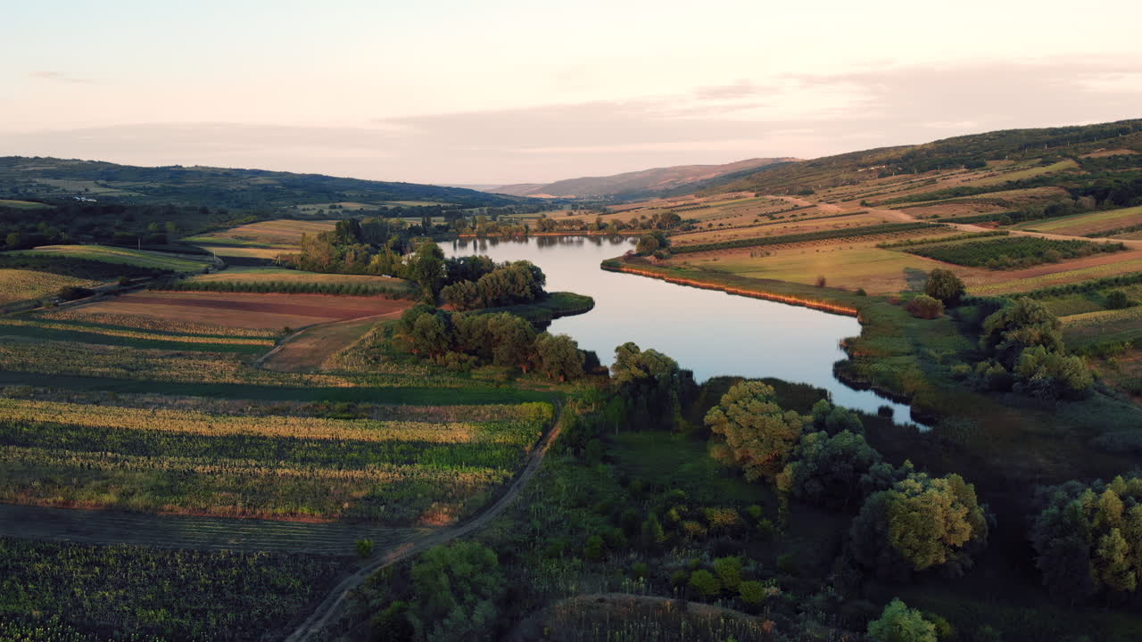 Una serena veduta aerea di un fiume che serpeggia tra i terreni agricoli durante l'ora d'oro