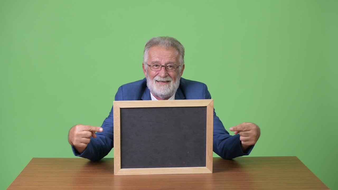 hombre de negocios barbudo y guapo contra un fondo verde.