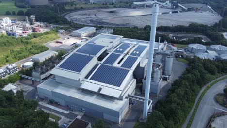 clean solar rooftop installation on modern office building aerial view with coal power station in background reversing tilt up