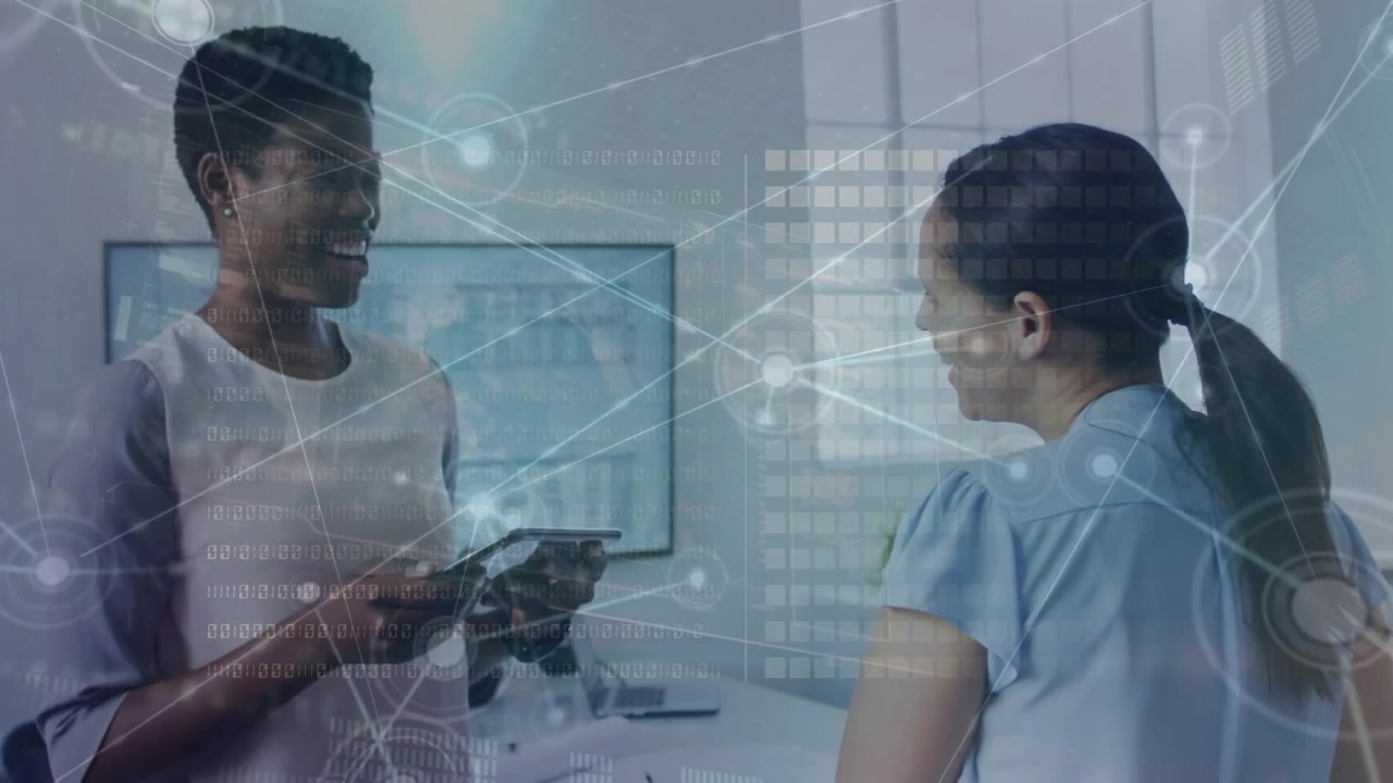 Two businesswomen discuss data processing in a modern office.