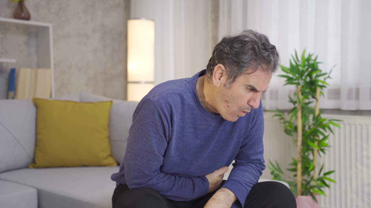 hombre maduro con dolor de estómago sufriendo en casa.